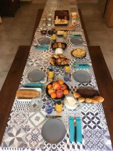 a long table with plates and food on it at Domaine Du Moulin Neuf in Ambillou