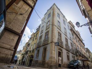 a tall white building on a city street at Historical Lisbon Apartments in Lisbon