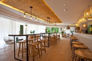 a restaurant with a bar with wooden tables and chairs at Ipanema Park in El Arenal