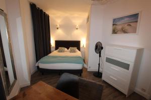 Habitación pequeña con cama y escritorio. en L'Emeraude en Saint-Malo