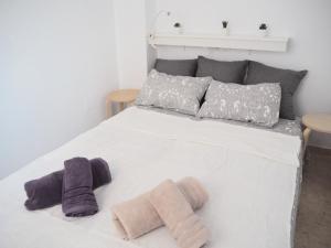 a white bed with two mitts on top of it at Amiga in Alicante