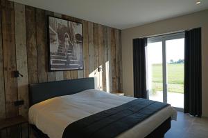 a bedroom with a bed and a sliding glass door at B&B Ten Doele in Middelkerke +47 photos
