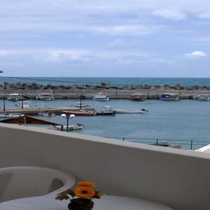 a bathroom with a view of a harbor with boats in the water at Kiveli in Milatos