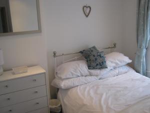 a bedroom with a bed with a pillow and a dresser at Drovers Cottage in Hayfield