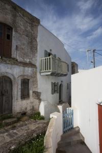 a white building with a balcony on the side of it at Pyrgos Stone House in Emporeiós
