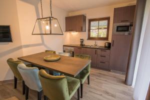 eine Küche und ein Esszimmer mit einem Holztisch und Stühlen in der Unterkunft Van der Valk Resort Linstow in Linstow