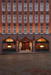 a large red brick building with two large windows at H+ Hotel Lübeck in Lübeck