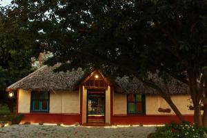 a small house with a thatched roof at Malgudi Farms in Bangalore
