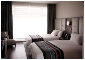 a hotel room with two beds and a window at Casa Grande Hotel in La Paz