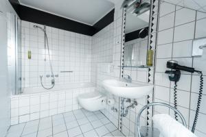 a white bathroom with a sink and a shower at Hotel am Rothenbaum in Hamburg