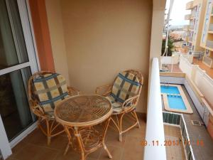 a balcony with a table and chairs and a swimming pool at Amarillo Apartment in Puerto de Mazarrón