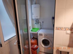 a small bathroom with a washing machine and a washer at Amarillo Apartment in Puerto de Mazarrón