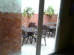 a patio with a table and chairs outside a window at Micro Hotel Condo Suites in Santo Domingo