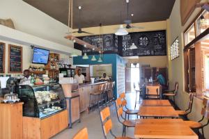 a restaurant with wooden tables and chairs and a counter at Galawa Beach Apartments in Diani Beach