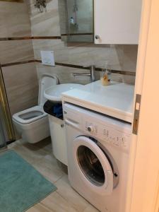 a bathroom with a washing machine and a toilet at Cozy apartment Centr Alanya in Alanya