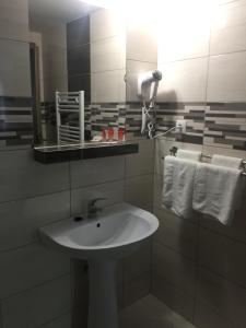 a bathroom with a sink and a mirror and towels at Vila Cristina in Sovata