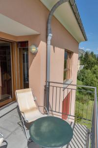 a table and a chair on a balcony at Chesa Viroula - Zuoz in Zuoz