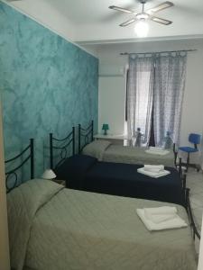 a bedroom with two beds and a ceiling fan at Casa Desir&egrave; in Catania