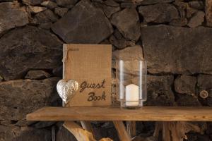 een kaars en een gastenboek op een houten tafel bij Graviana - Pedra Azul Charming House in Lagoa +41 foto's