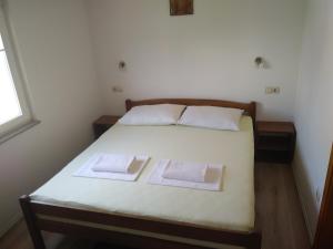 een slaapkamer met een bed met twee handdoeken erop bij Guest House Andre in Međugorje