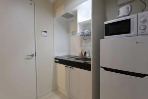 a small kitchen with a white refrigerator and a sink at Shibuya Anon #B102 in Tokyo