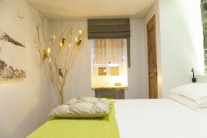 a bedroom with a white bed and a window at Graviana - Pedra Lima Charming House in Lagoa