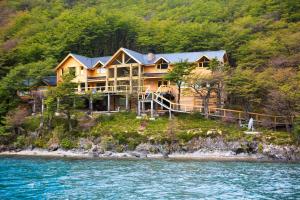 a large house on the shore of the water at Aguas Arriba Lodge in El Chalten