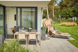 eine Terrasse mit einem Tisch und Stühlen im Hof in der Unterkunft Villa Vogue by Binz Exquisit | No.3 in Binz