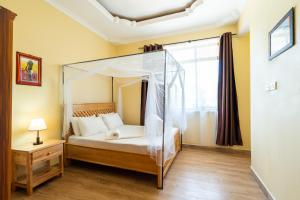 
a bedroom with a large bed and a large window at Rayan Apartments & Safaris in Arusha
