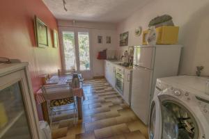 a kitchen with a refrigerator and a washer and dryer at Villa Violette in Ensuès-la-Redonne