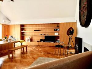 a living room with a couch and a television at Groove-Wood Loft in Vila Nova de Gaia