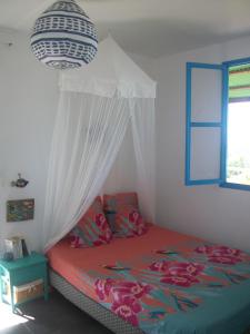 a bedroom with a bed with a canopy and a window at mango tree lodge in Bouillante