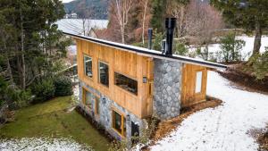 uma casa na floresta com neve no chão em Quinto Elemento Bariloche em San Carlos de Bariloche
