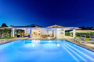 a swimming pool in front of a house at Ville D'Ogliastra in Cardedu