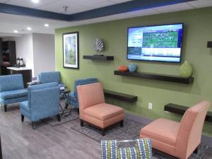 a waiting room with chairs and a tv on the wall at Best Western Rock Hill in Rock Hill