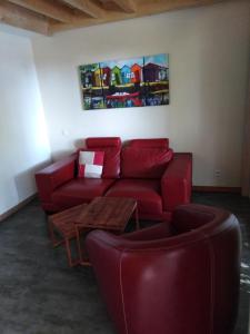 ein Wohnzimmer mit einem roten Sofa und einem Tisch in der Unterkunft Duplex Bord Bassin d'Arcachon in Arès