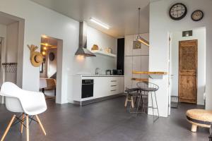 een keuken met witte kasten en een tafel en stoelen bij Graviana - Pedra Negra Charming House in Lagoa