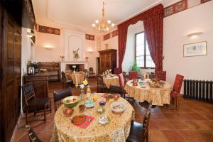 uma sala de jantar com mesas e cadeiras e uma lareira em Chateau De Picomtal em Crots