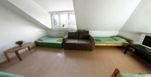 a living room with a couch and a chair at Wilanowska Hostel in Warsaw