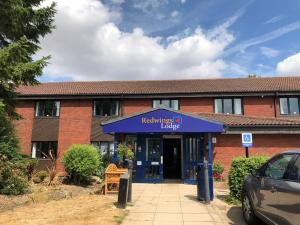 un edificio con una señal azul delante de él en Redwings Lodge Rutland en Uppingham