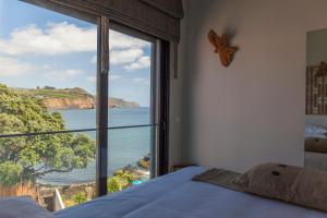 een slaapkamer met een groot raam met uitzicht op de oceaan bij Graviana - Pedra Negra Charming House in Lagoa