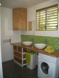 a bathroom with two sinks and a washing machine at mango tree lodge in Bouillante