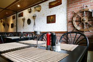 a table in a restaurant with tables and chairs at Hotel Weserstuben in Bodenwerder