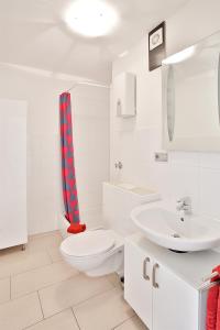 a white bathroom with a toilet and a sink at Ferienwohnung Kaarst in Kaarst