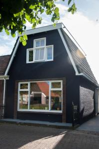 una casa negra con ventanas en el lateral. en Heerlijk Huis aan het IJsselmeer en Stavoren