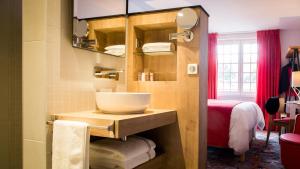 een badkamer met een kom op een wastafel in een kamer bij Hotel Berria in Hasparren