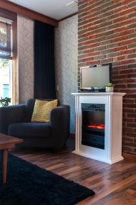 a living room with a fireplace with a tv on top at Heerlijk Huis aan het IJsselmeer in Stavoren
