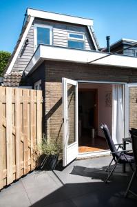 a house with an open door and a patio at Heerlijk Huis aan het IJsselmeer in Stavoren