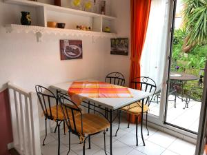 uma sala de jantar com uma mesa e cadeiras e uma janela em Ferienhaus Cogolin mit Wintergarten-Terrasse em Grimaud