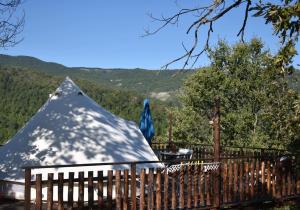 una pirámide cubierta de nieve detrás de una valla de madera en Podere di Maggio - Canvas tent Chestnut en Santa Fiora